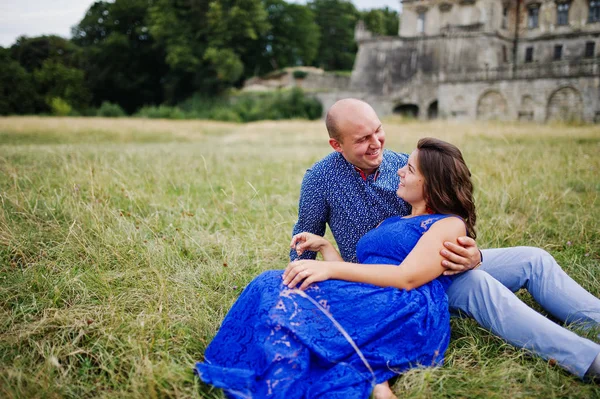 Hermosa pareja enamorada contra el viejo castillo. Chica en vestido azul . — Foto de Stock