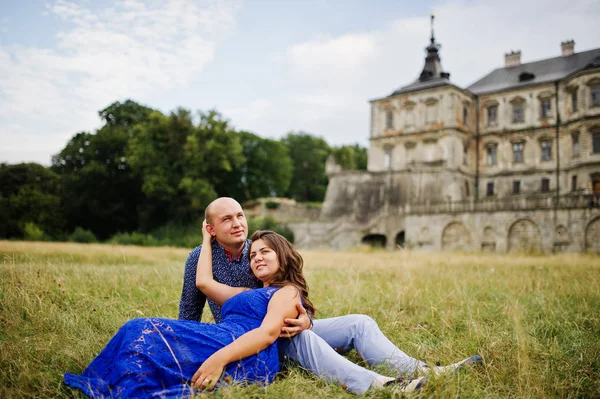 Bella coppia innamorata contro il vecchio castello. Ragazza in abito blu . — Foto Stock