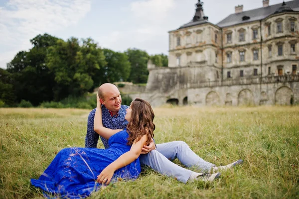 Krásný pár v lásce proti starý hrad. Dívka v modrých šatech. — Stock fotografie