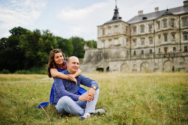 Hermosa pareja enamorada contra el viejo castillo. Chica en vestido azul . — Foto de Stock