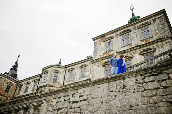 Encantador casal apaixonado contra o velho castelo. Menina em vestido azul . — Fotografia de Stock