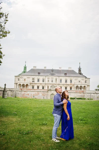 Hermosa pareja enamorada contra el viejo castillo. Chica en vestido azul . —  Fotos de Stock