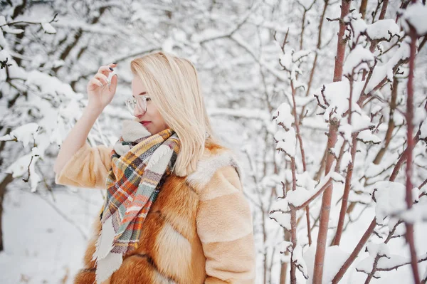 Portraiy of blonde girl in glasses, red fur coat and scarf at wi — Stock Photo, Image