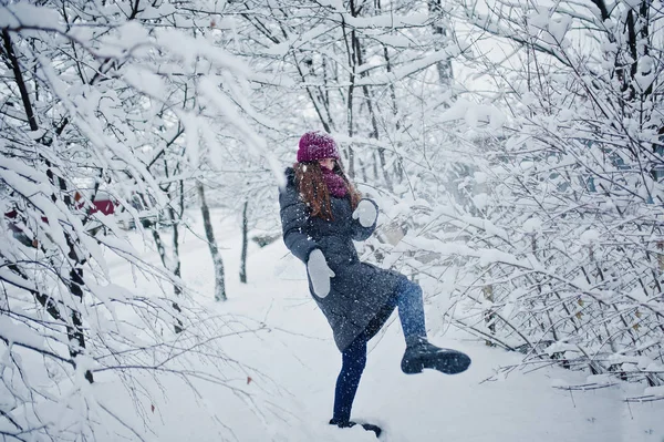 Portret dziewczynki w zimowy śnieżny dzień w pobliżu śniegu objętych drzewa. — Zdjęcie stockowe
