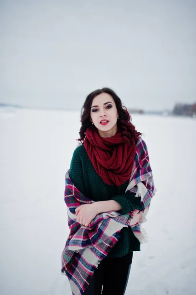 Chica morena en suéter verde y bufanda roja con cuadros al aire libre —  Fotos de Stock