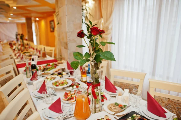 Hochzeitstisch mit roten Rosen im Restaurant. — Stockfoto