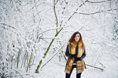 Elegance kıvırcık kız kış, karlı orman Park'ta kürk paltolu.