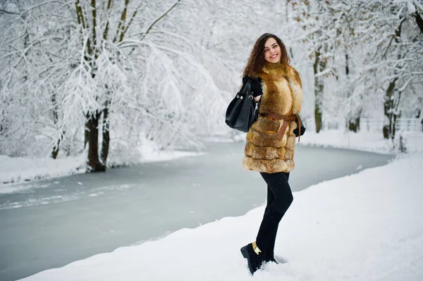 Elegancia chica rizada en abrigo de piel en el parque del bosque nevado en invierno . — Foto de Stock