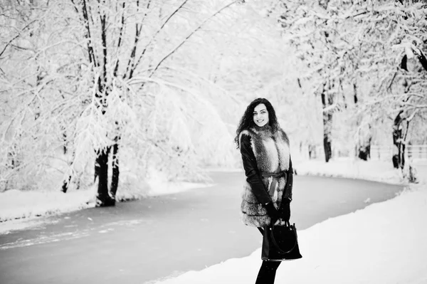 Elegancia göndör lány a snowy forest park téli bundában. — Stock Fotó