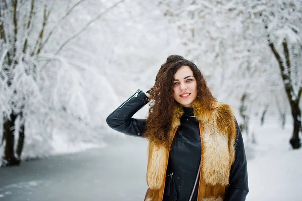 Menina encaracolado elegância em casaco de pele no parque florestal nevado no inverno . — Fotografia de Stock