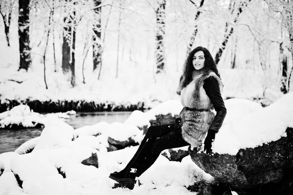 Elégance fille bouclée en manteau de fourrure au parc forestier enneigé en hiver . — Photo