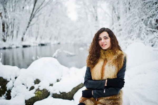 Menina encaracolado elegância em casaco de pele no parque florestal nevado no inverno . — Fotografia de Stock