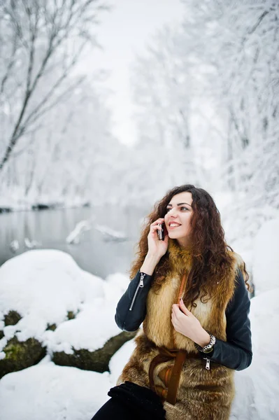 Menina encaracolado elegância em casaco de peles com telefone celular em inimigos nevados — Fotografia de Stock