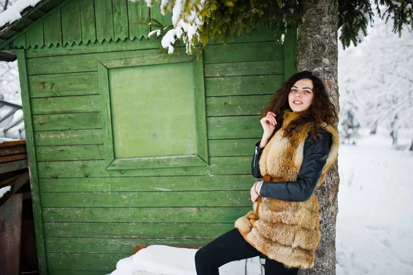 Elégance fille bouclée en manteau de fourrure au parc forestier enneigé agasinst gr — Photo