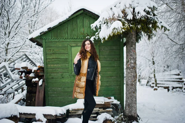 Elegance curly girl in fur coat at snowy forest park agasinst gr — Stock Photo, Image