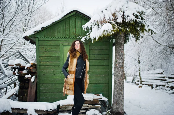 Elégance fille bouclée en manteau de fourrure au parc forestier enneigé agasinst gr — Photo