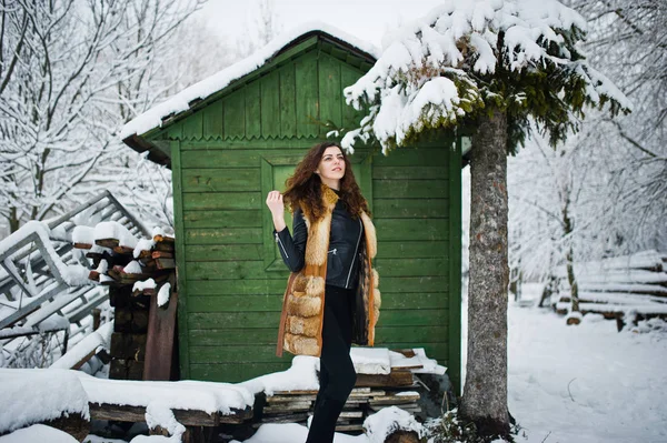 Elégance fille bouclée en manteau de fourrure au parc forestier enneigé agasinst gr — Photo