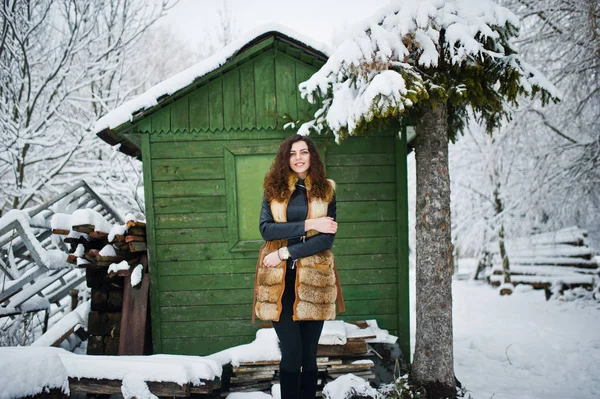 Elégance fille bouclée en manteau de fourrure au parc forestier enneigé agasinst gr — Photo