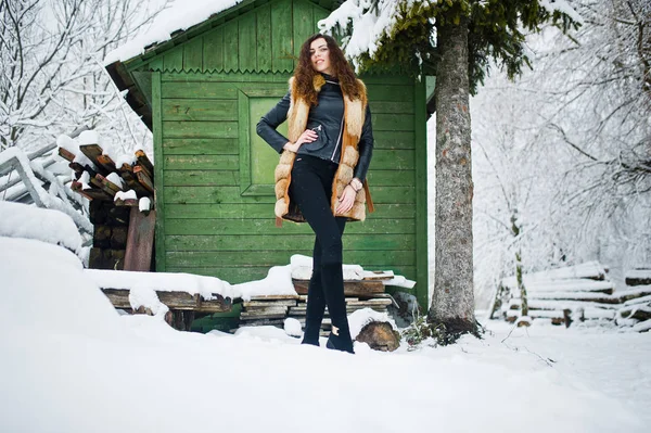 Eleganz lockiges Mädchen im Pelzmantel im verschneiten Waldpark — Stockfoto