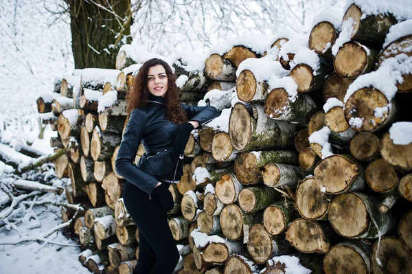 Elégance fille bouclée en veste en cuir au parc forestier enneigé à wi — Photo