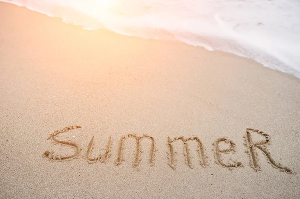 Close-up photo of sand inscription "summer" by the foamy waves. — Stock Photo, Image