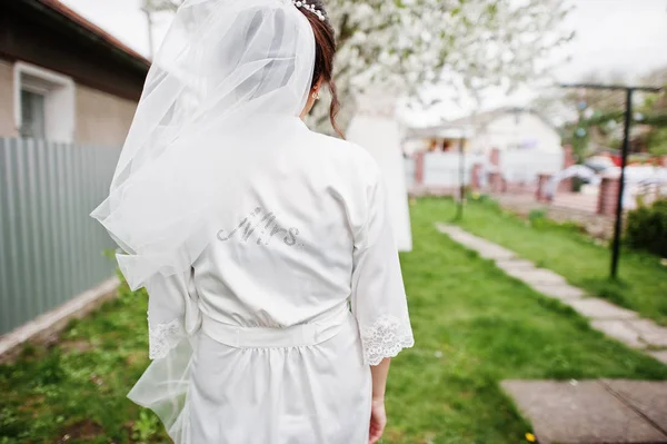 A portrait of a pretty bride posing next to her dress outdoors n — Stock Photo, Image