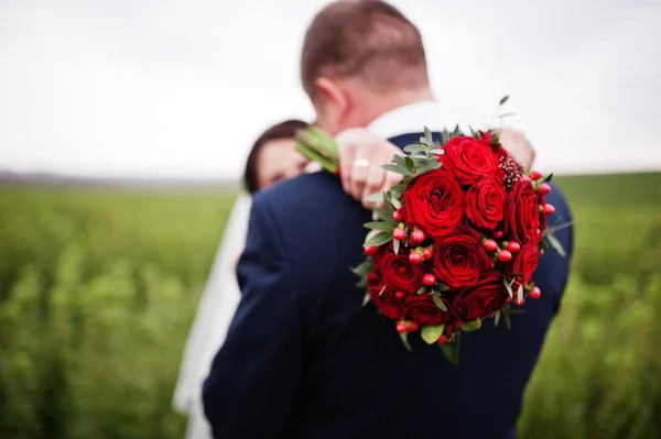 Vonzó fiatal esküvői pár pózol a feketeribizli-mező — Stock Fotó