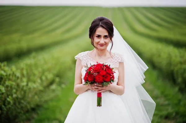 Portrét něžný krásná nevěsta pózuje s její červené svatební — Stock fotografie