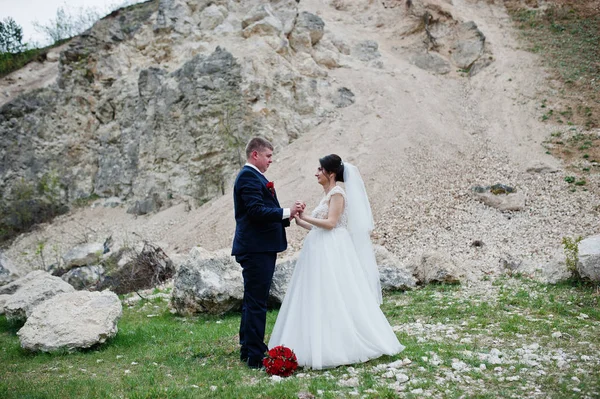 Romantique couple nouvellement marié posant et marchant dans le comte rocheux — Photo