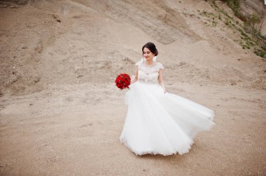 Bir düğün buket kırmızı çiçek tutan bir gelin portresi ve