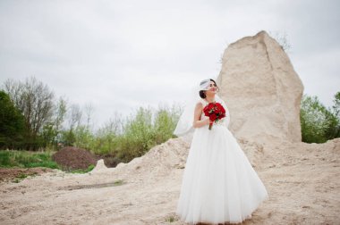 Bir düğün buket kırmızı çiçek tutan bir gelin portresi ve