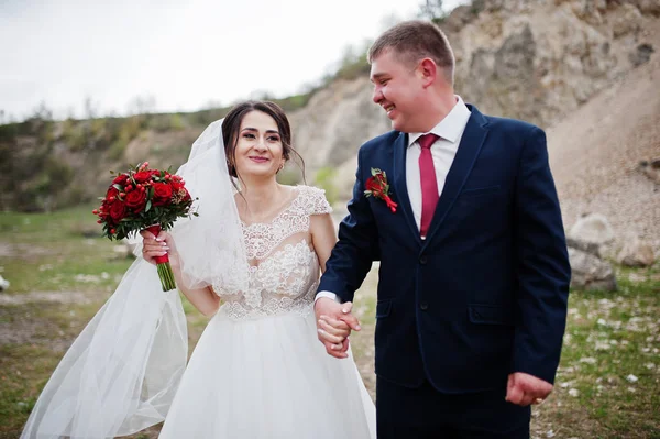 Romantiska nygift par poserar och promenader i steniga land — Stockfoto