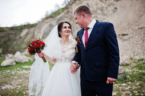 Romantiska nygift par poserar och promenader i steniga land — Stockfoto