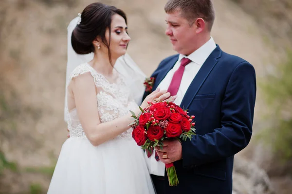 Romantique couple nouvellement marié posant et marchant dans le comte rocheux — Photo