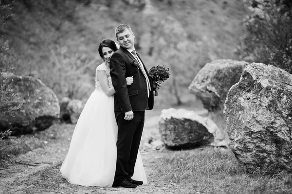 Romantiska nygift par poserar och promenader i steniga land — Stockfoto