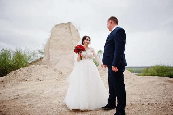 Молодая супружеская пара позирует в песчаном карьере в день свадьбы . — стоковое фото