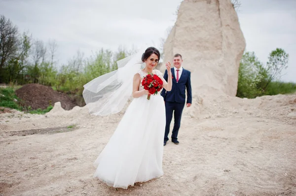 Young wedding couple posing in sand quarry on their wedding day. — Stock Photo, Image