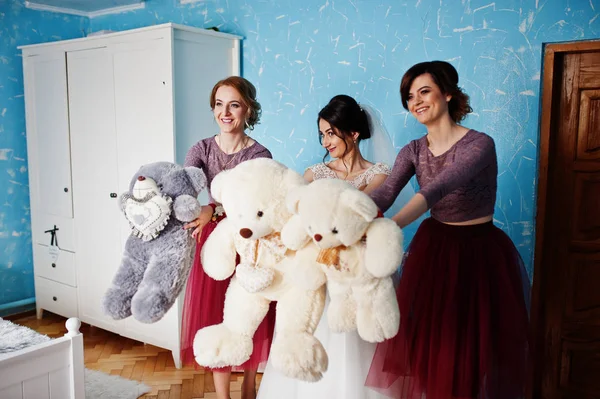 Dama de honra e uma noiva posando com brinquedos de ursinho de pelúcia em seu quarto . — Fotografia de Stock