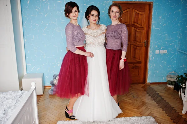 Hermosa novia posando con damas de honor en su habitación en una boda — Foto de Stock