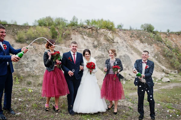 Pareja de bodas, padrino y damas de honor mirando al padrino op — Foto de Stock