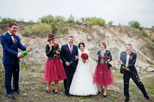Pareja de bodas, padrino y damas de honor mirando al padrino op — Foto de Stock