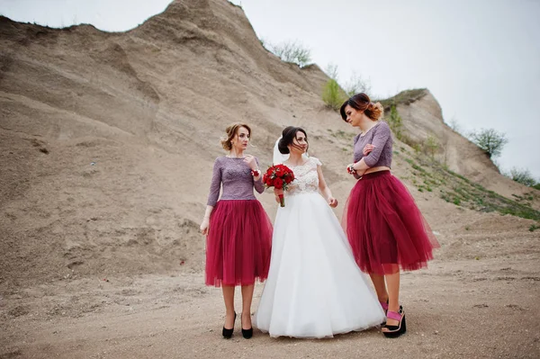 Pózol a lány koszorúslányok homok kőbányában neki esküvő menyasszony — Stock Fotó