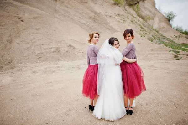 Noiva posando com suas damas de honra na pedreira de areia em seu casamento — Fotografia de Stock