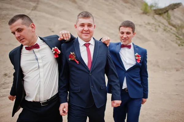 Groom posant avec les garçons d'honneur dans une carrière de sable le jour d'un mariage . — Photo