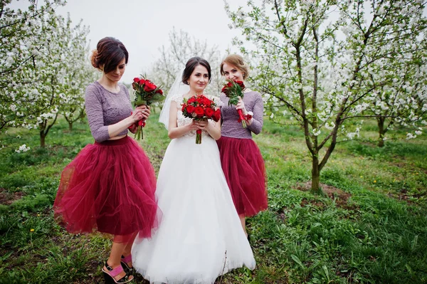 Fabulous bride and her bridesmaids holding bouquets and feeling — Stock Photo, Image