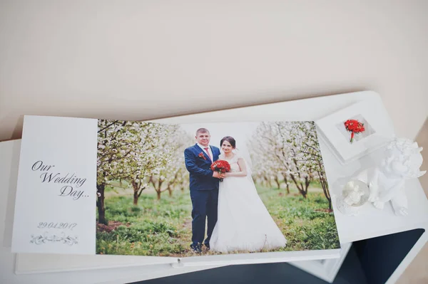 Pages of elegant photobook or wedding album on a small table. — Stock Photo, Image