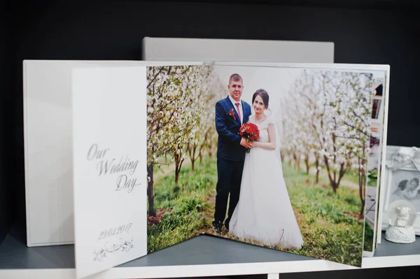 Páginas de photobook elegante ou álbum de casamento em uma pequena mesa . — Fotografia de Stock