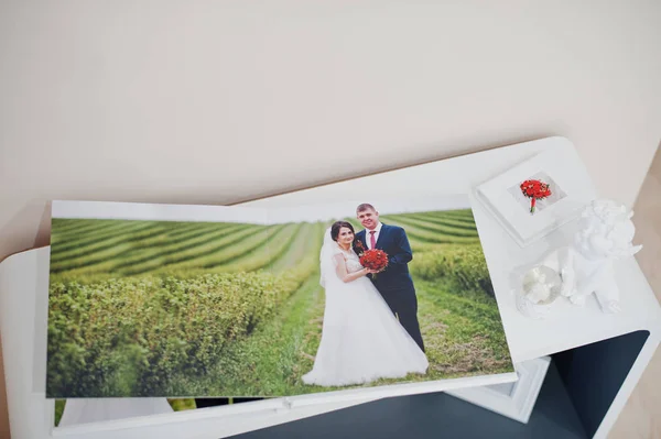 Pages of elegant photobook or wedding album on a small table. — Stock Photo, Image