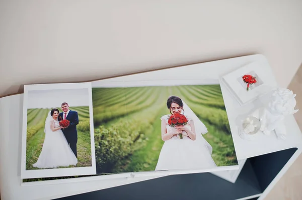 Seiten mit elegantem Fotobuch oder Hochzeitsalbum auf einem kleinen Tisch. — Stockfoto