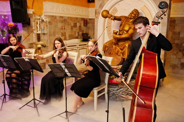 Cuarteto de cuerda tocando instrumentos en el restaurante en la boda —  Fotos de Stock